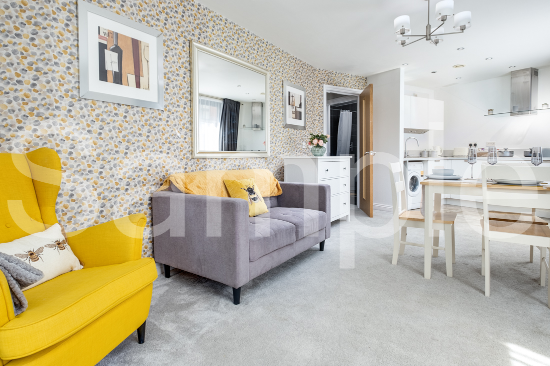 Open-plan lounge and dining area leading through to a white kitchen