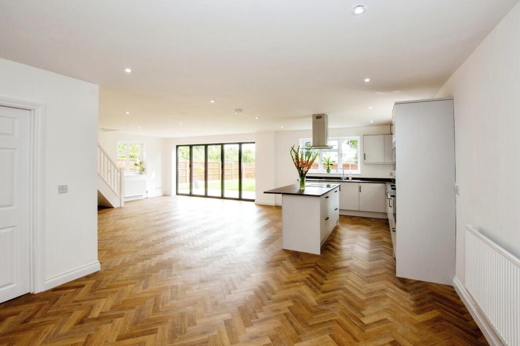 Dining area beside the kitchen with herringbone flooring and garden outlook