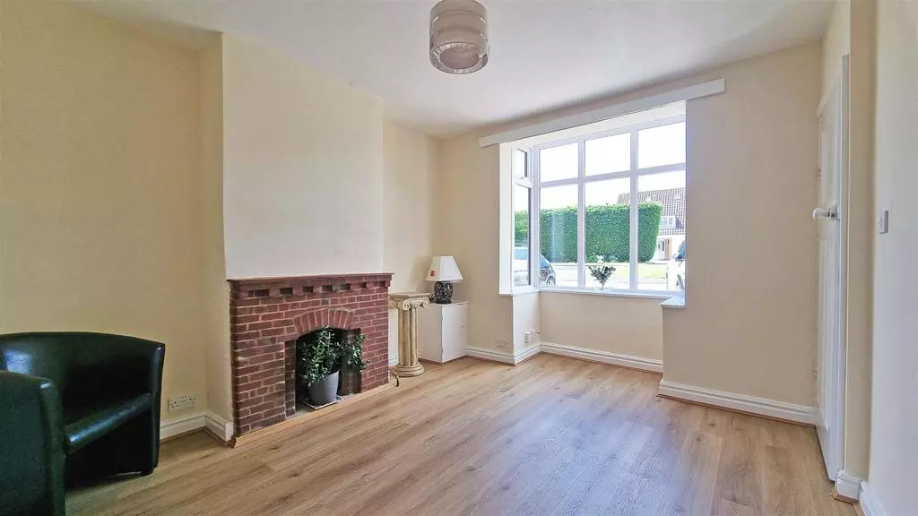Living room with bay window, restored brick fireplace and new oak-effect flooring