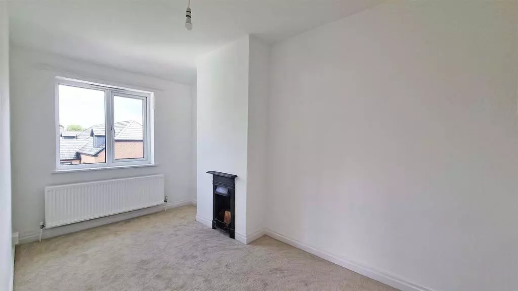 Second bedroom with cast iron fireplace, new radiator and neutral decoration