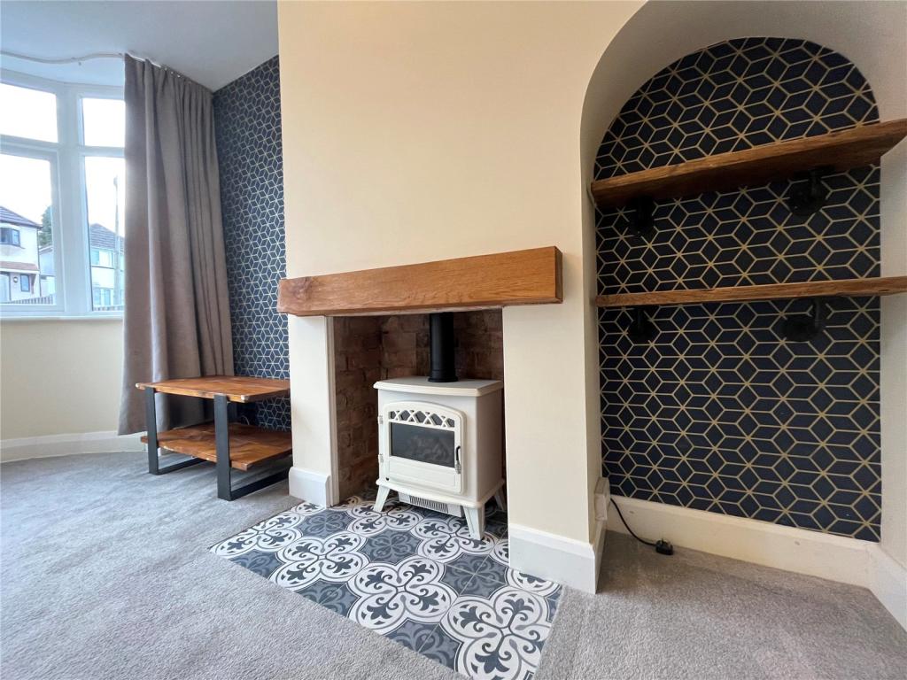Feature fireplace with oak mantel, log burner and patterned hearth tiles