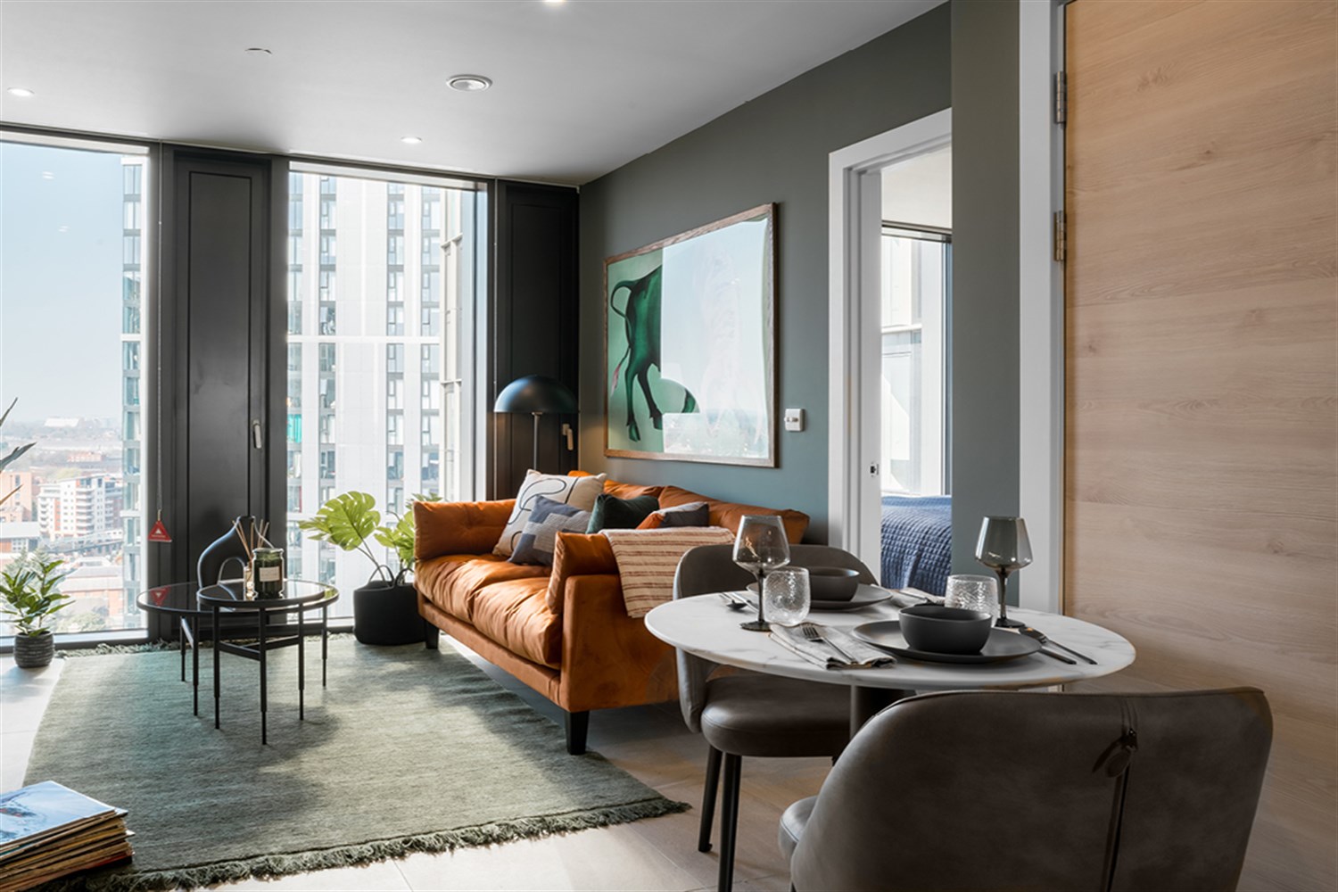 Living and dining space with orange sofa and set dining table