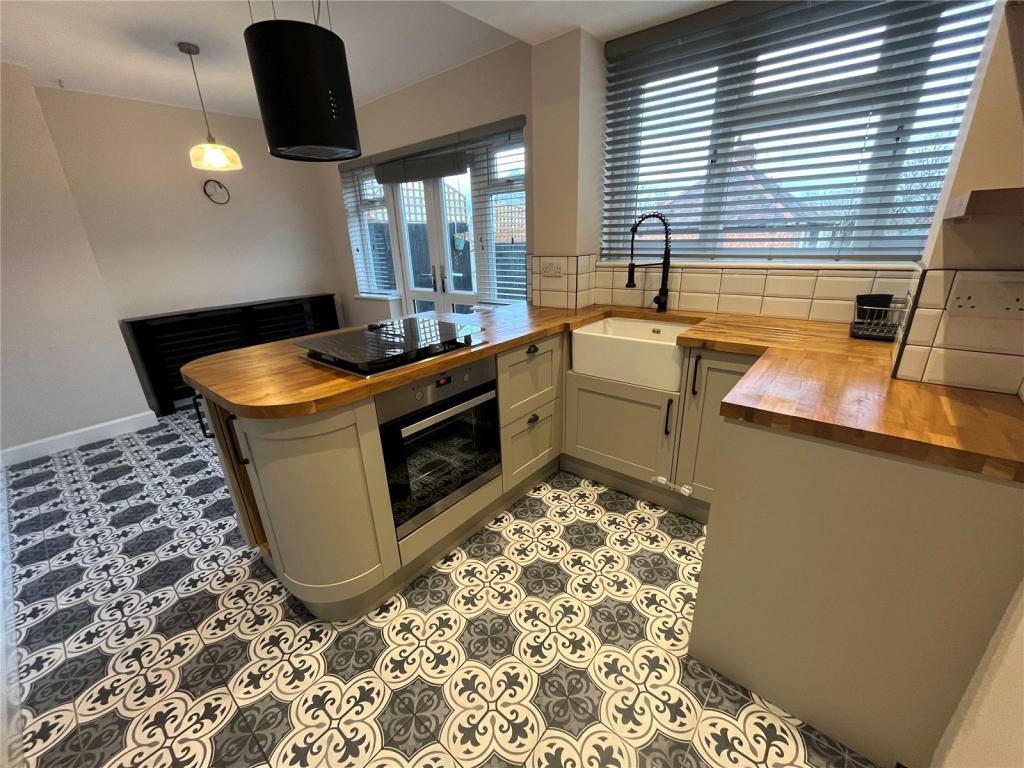 Completed kitchen at Project Meadfoot with island, patterned floor tiles and timber worktops