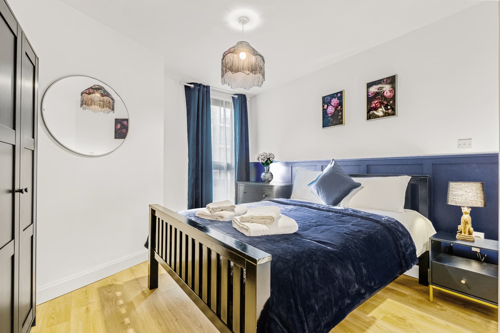 Bedroom with round mirror, wardrobe and coordinated artwork