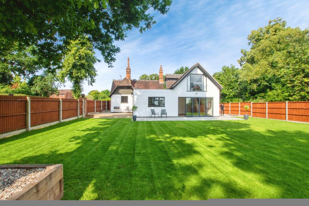 Completed rear elevation with white render, restored chimneys and landscaped lawn