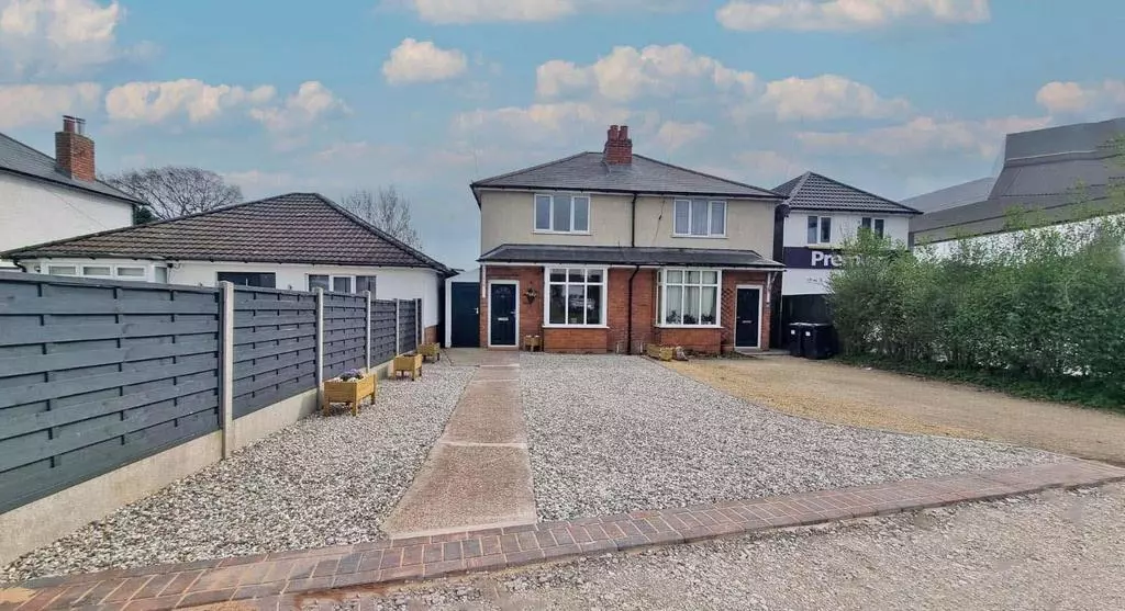 Completed front elevation of Project Oakfield with new render, black composite door and gravelled driveway