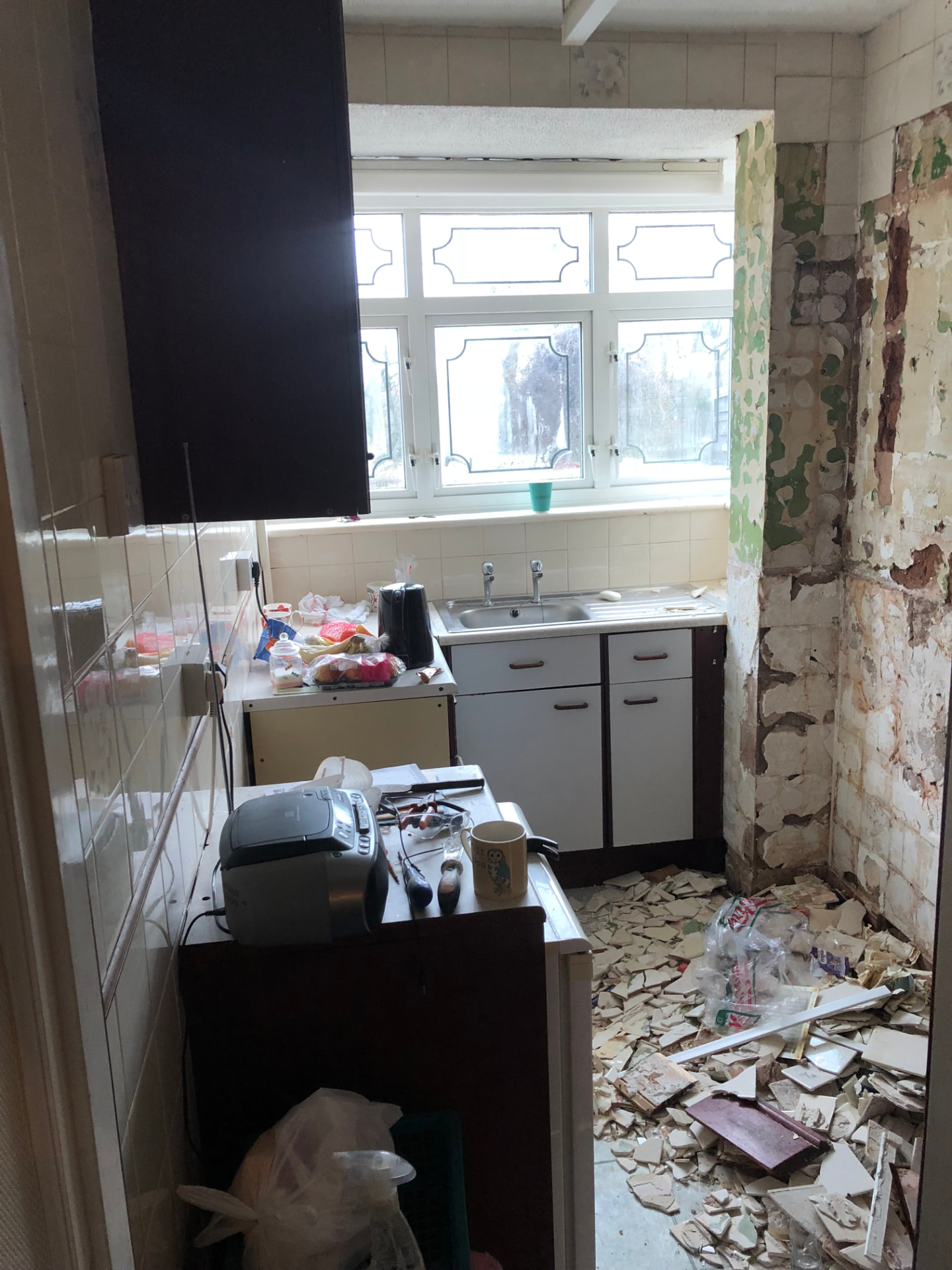 Kitchen before works stripped back with dated units and tiles removed from the walls