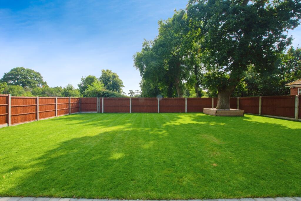 Landscaped rear lawn with mature oak tree and new fencing